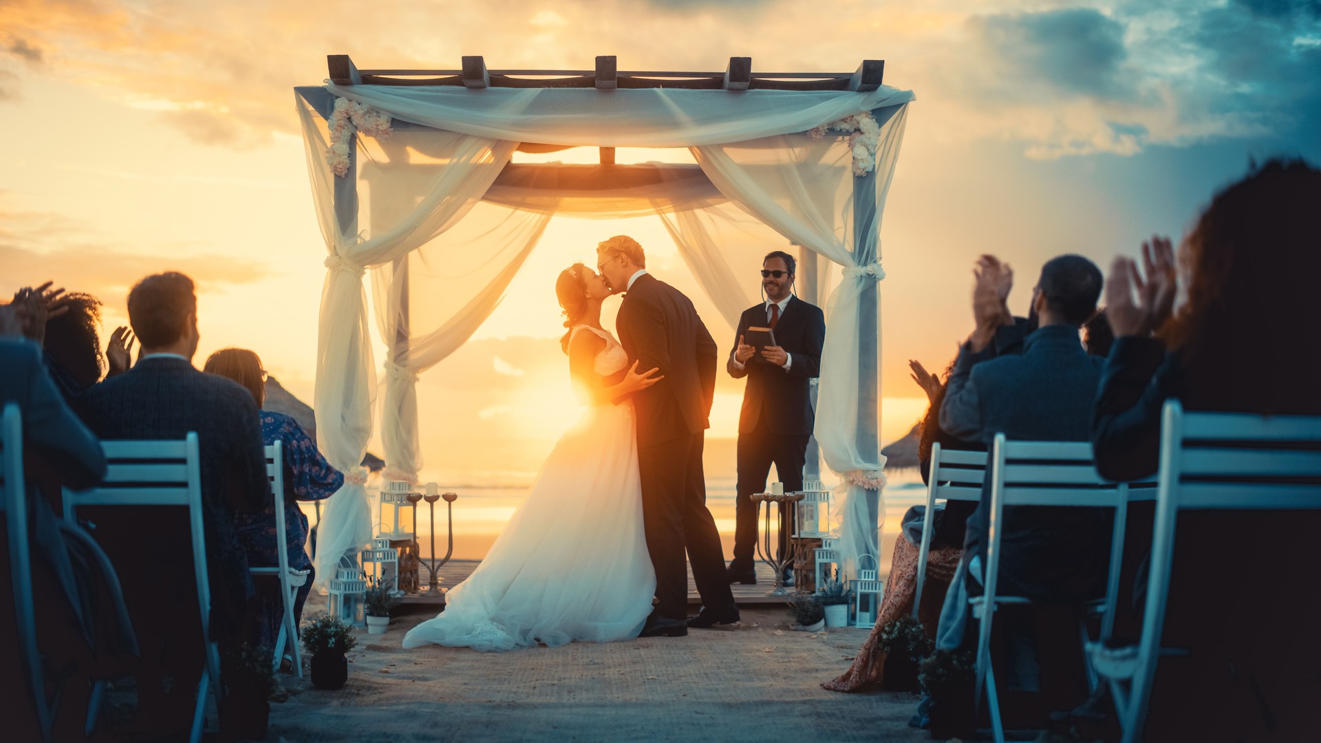 Beautiful Bride and Groom During an Outdoors Wedding Ceremony on an Ocean Beach at Sunset. Perfect Venue for Romantic Couple to Get Married, Exchange Rings, Kiss and Share Celebrations with Friends.