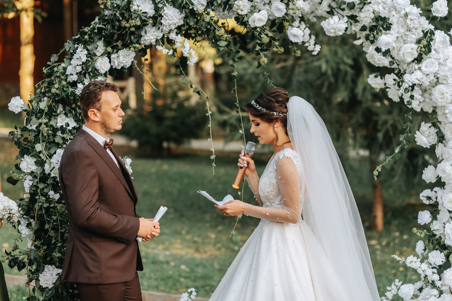 Beautiful wedding couple on the wedding autumn ceremony. The bride and groom exchange vows