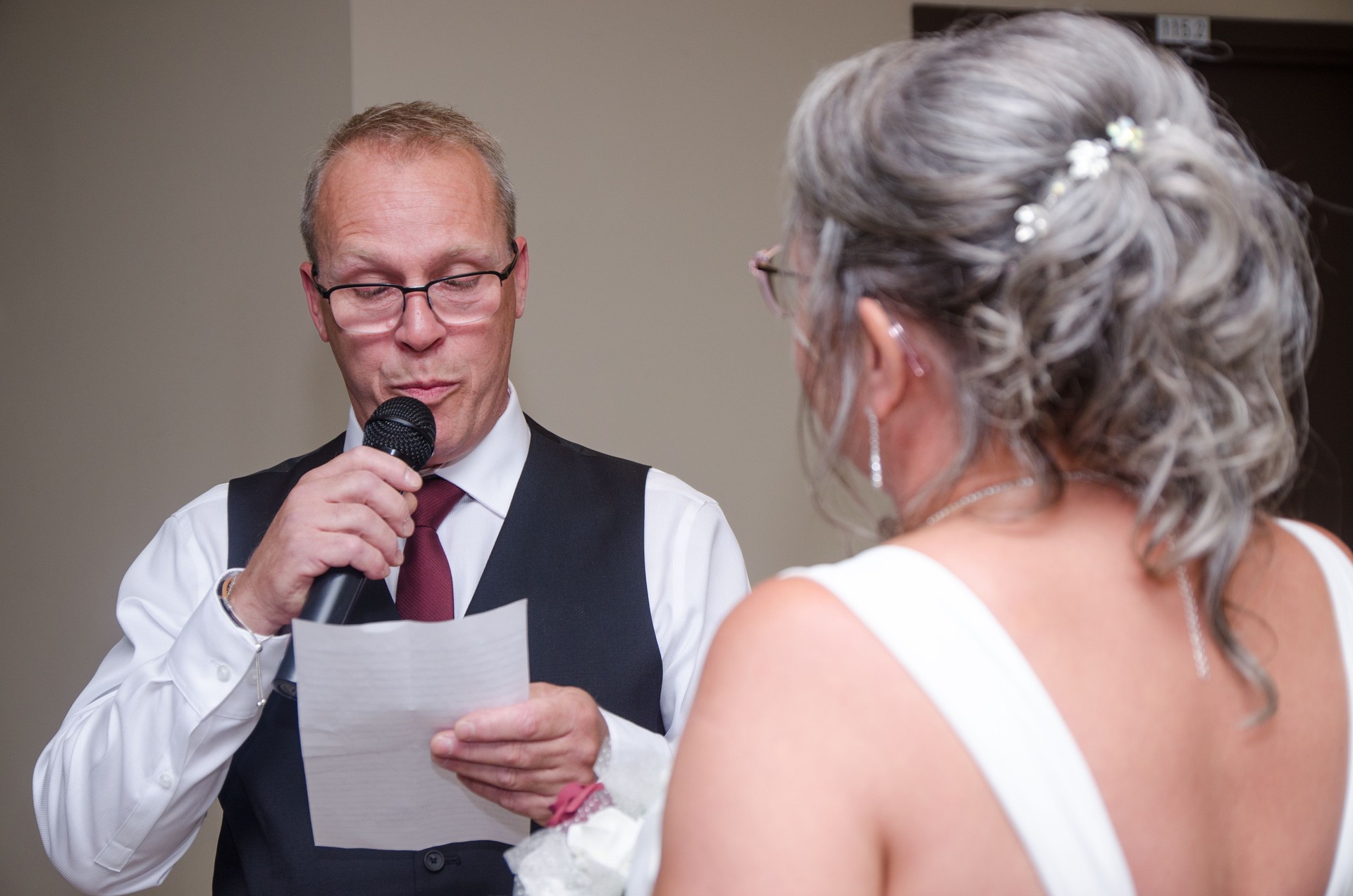 Groom reading wedding vows to bride